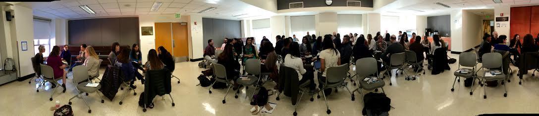Panoramic image of a classroom filled with students doing group work.