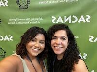 Headshot of two smiling people with long dark hair.