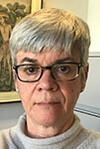 Headshot of person with short white hair and glasses.