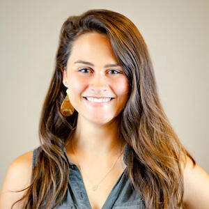 Headshot of smiling person with long dark hair.